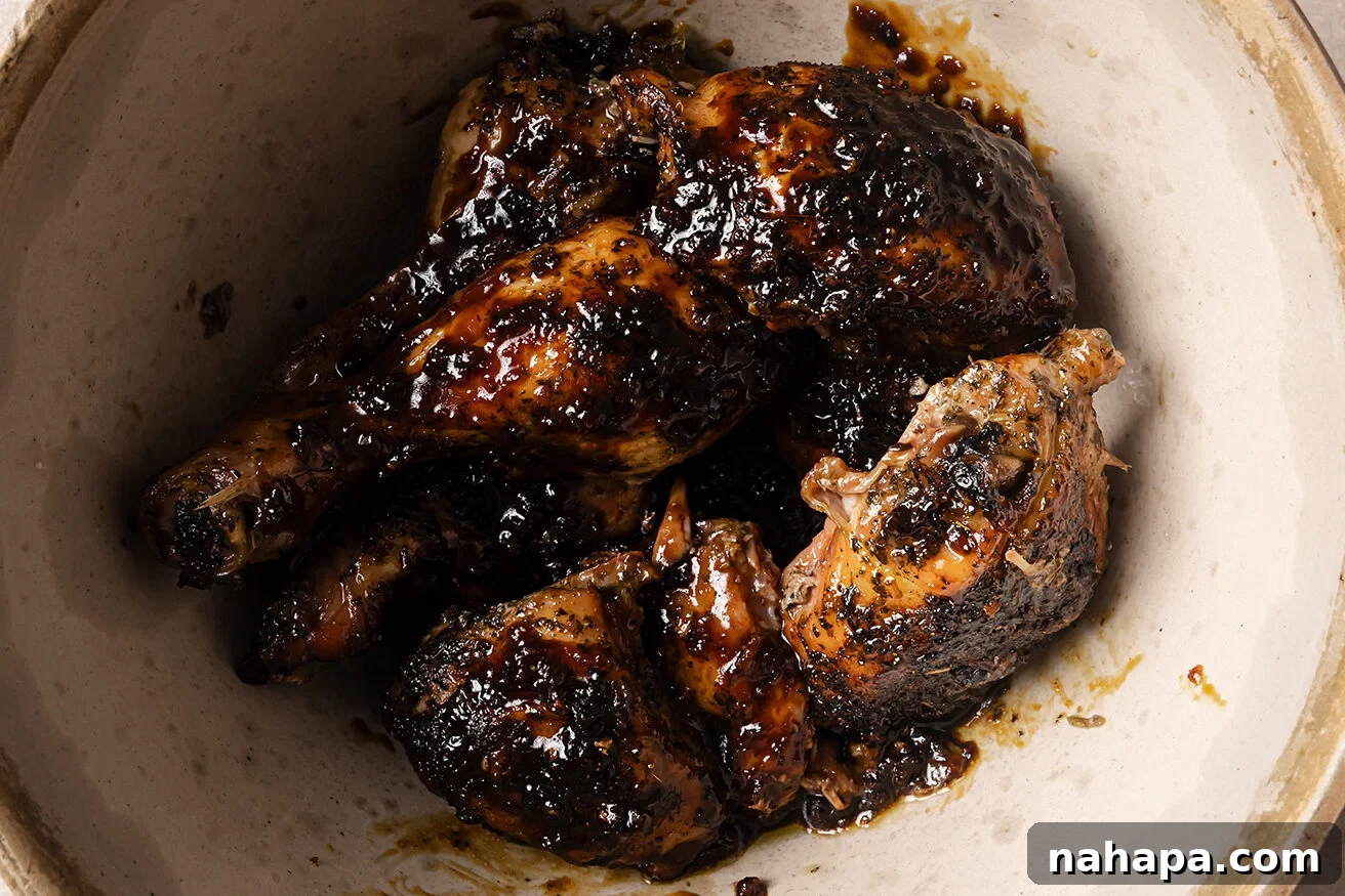 Turkey wings in a bowl topped with an orange glaze. 