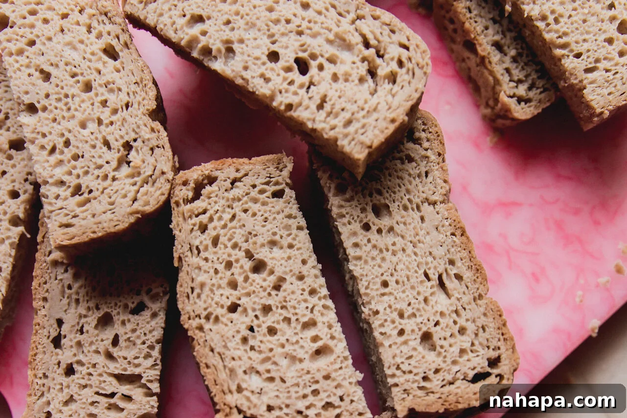 Gluten free bread sliced in half on a cutting board.