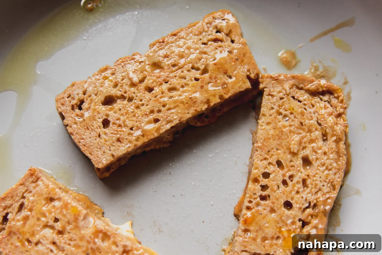 Gluten free french toast sticks frying in a pan.