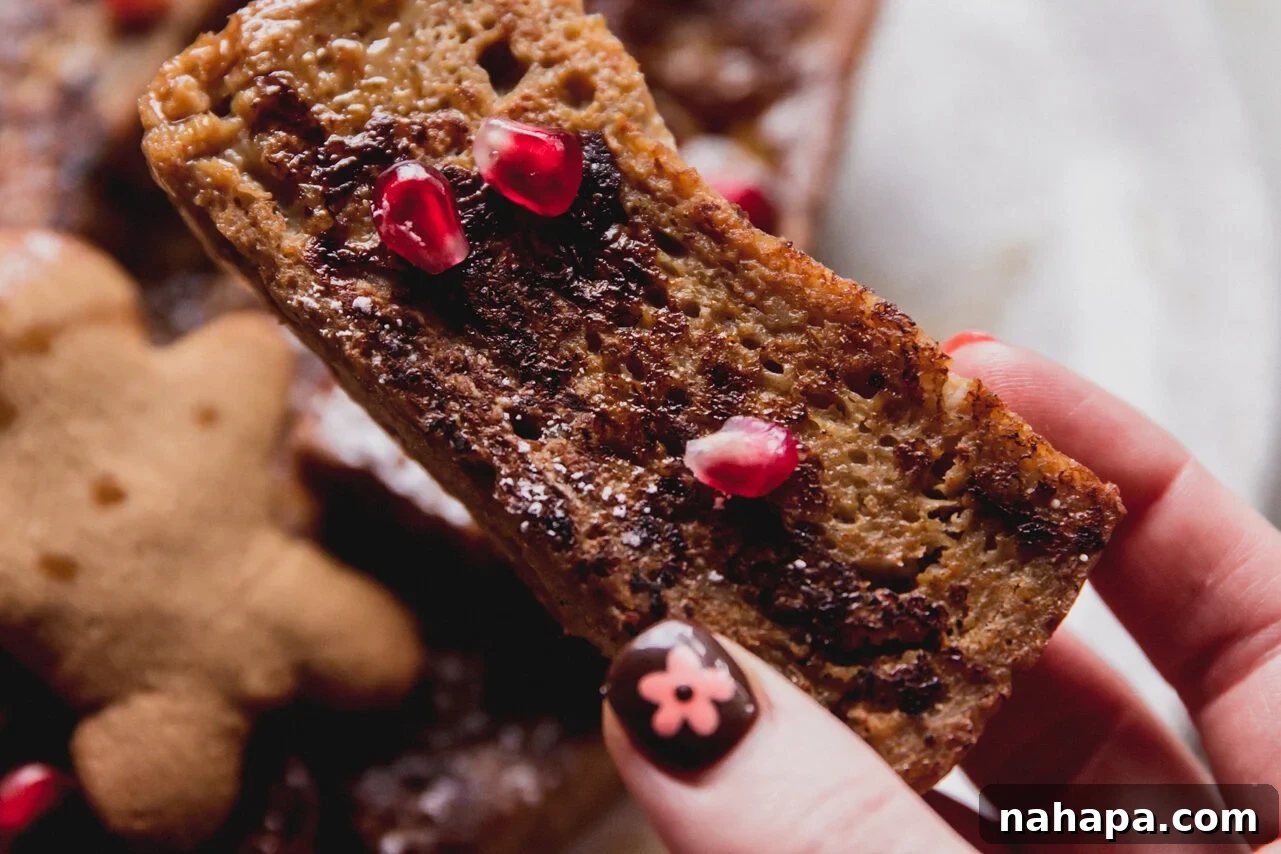 Cooked gluten free french toast sticks topped with pomegranate seeds. 