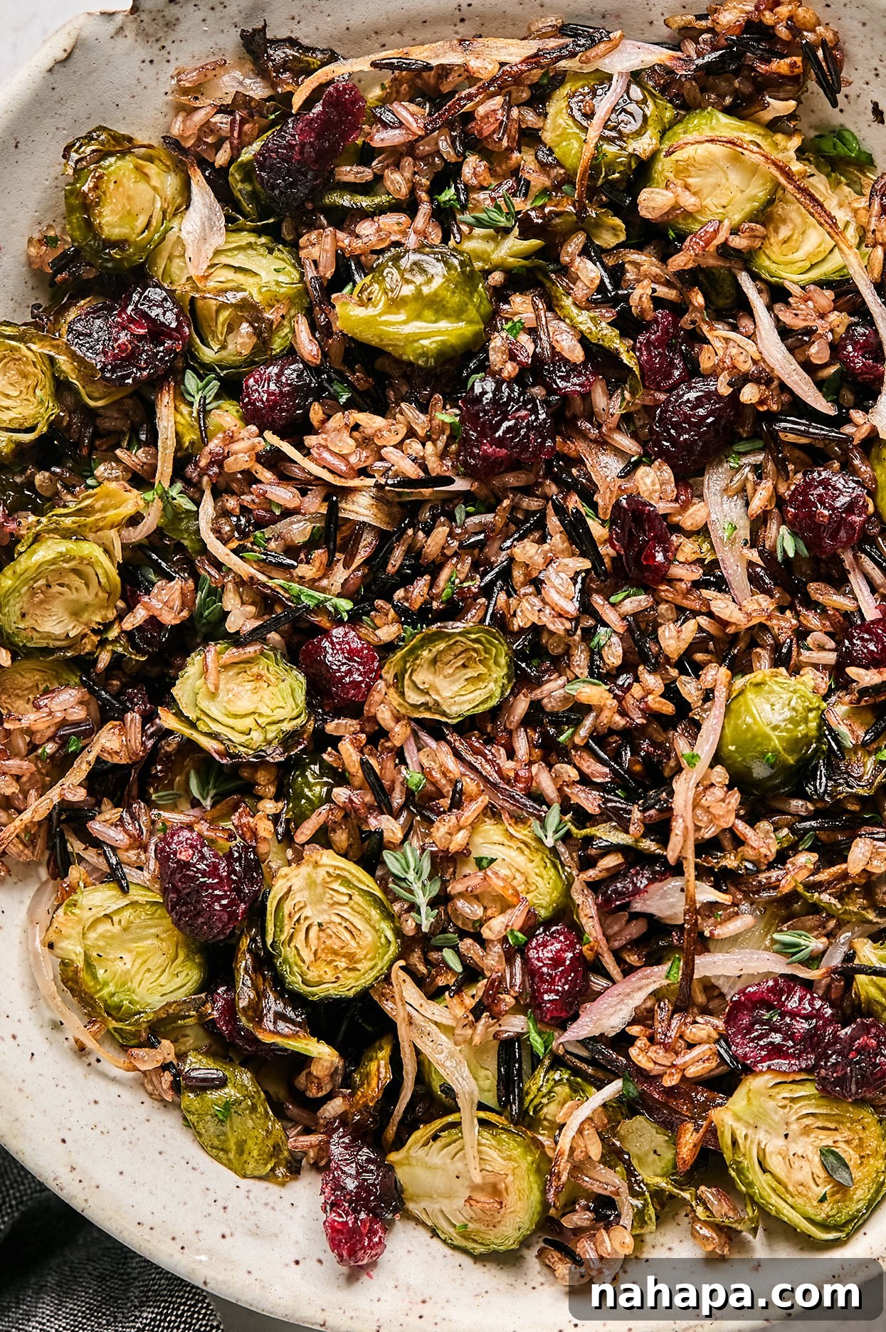 Crisp wild rice pilaf with brussels sprouts, and dried cranberries in a large bowl.