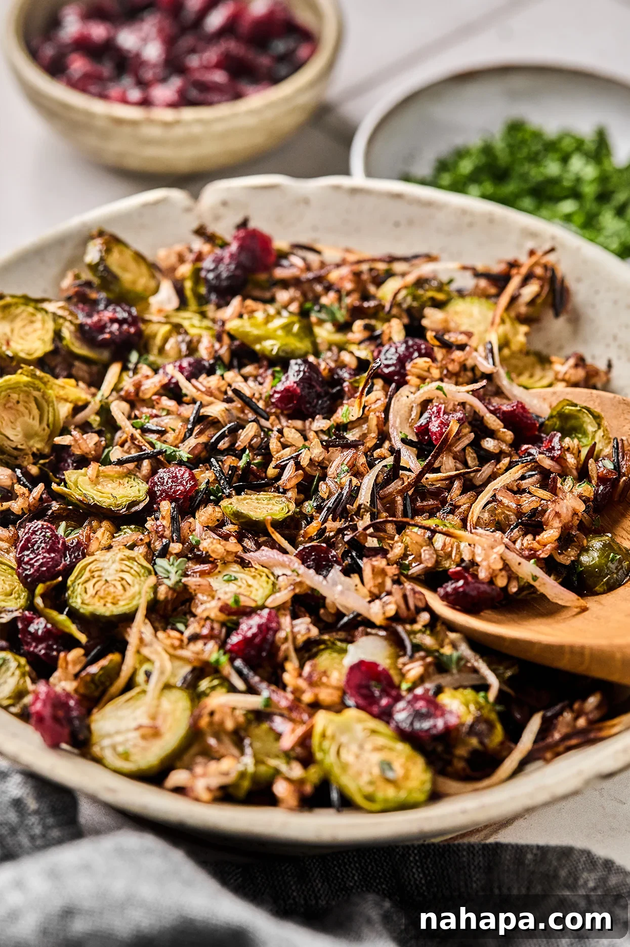 Crispy wild rice pilaf in a bowl with a wooden spoon.