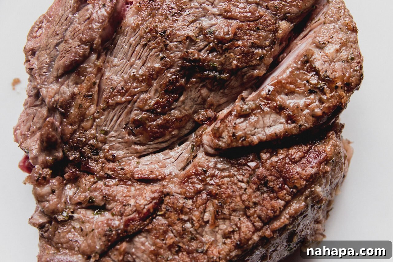 French Onion Braised Beef 6 A generously sized chuck roast, beautifully browned and seared on all sides, resting in a Dutch oven after being cooked.