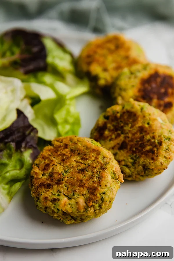 Three golden brown salmon cakes on a plate