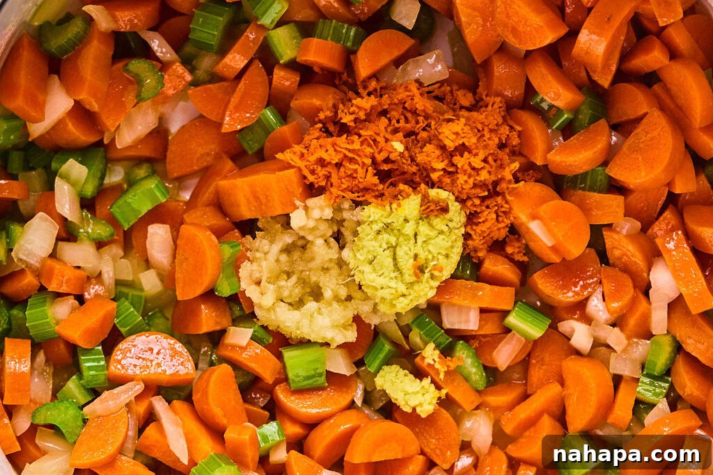 Sautéed vegetables in the pot, with minced garlic, grated fresh ginger, and grated fresh turmeric added, releasing their potent aromas.