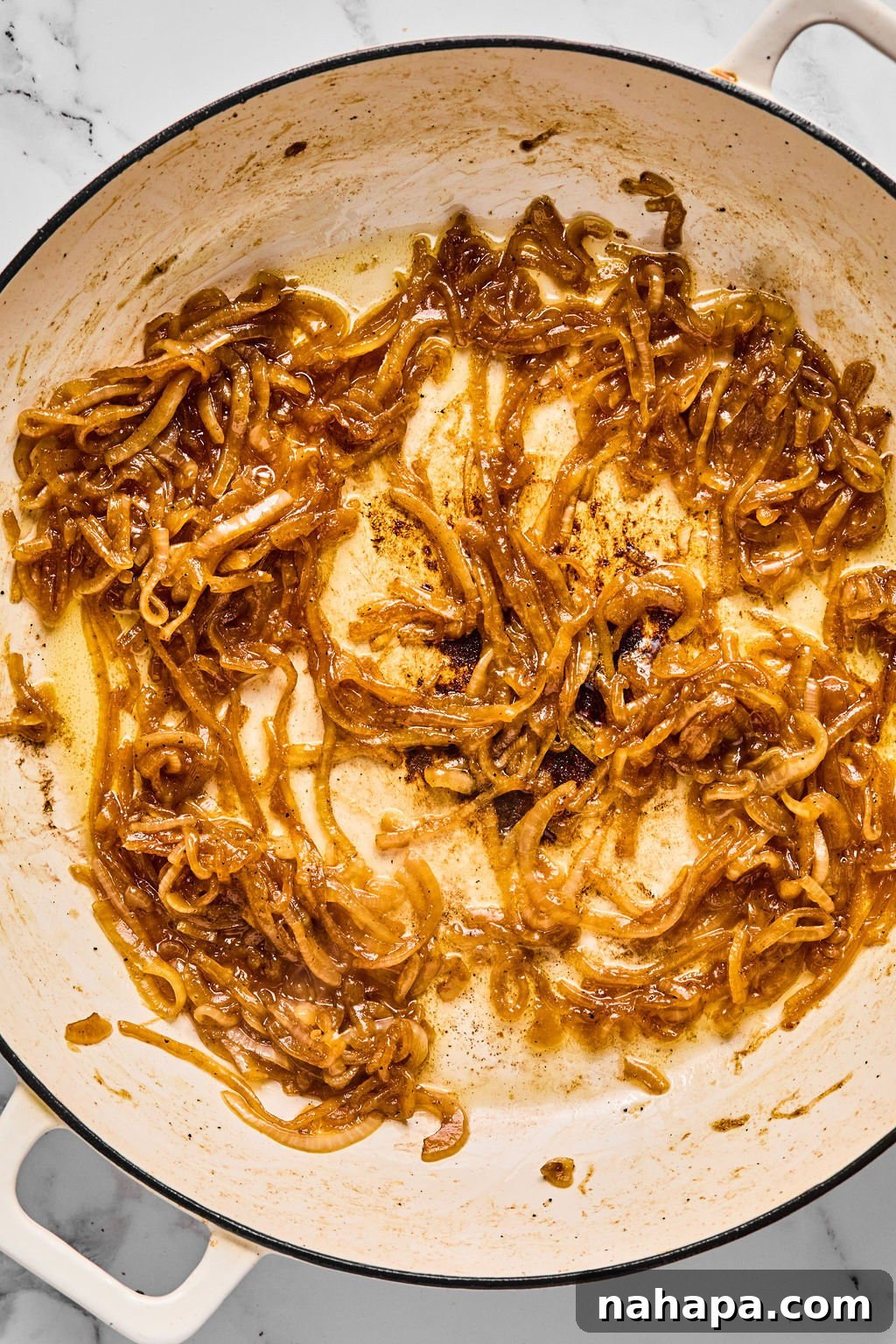 Deeply caramelized onions in the pan, showcasing their golden-brown hue and soft texture.