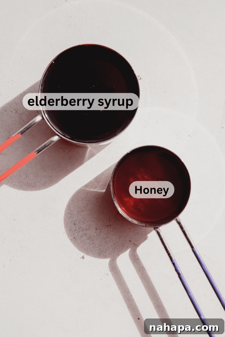 Two measuring cups filled with elderberry syrup and honey, showcasing the simple, wholesome ingredients for homemade lollipops.