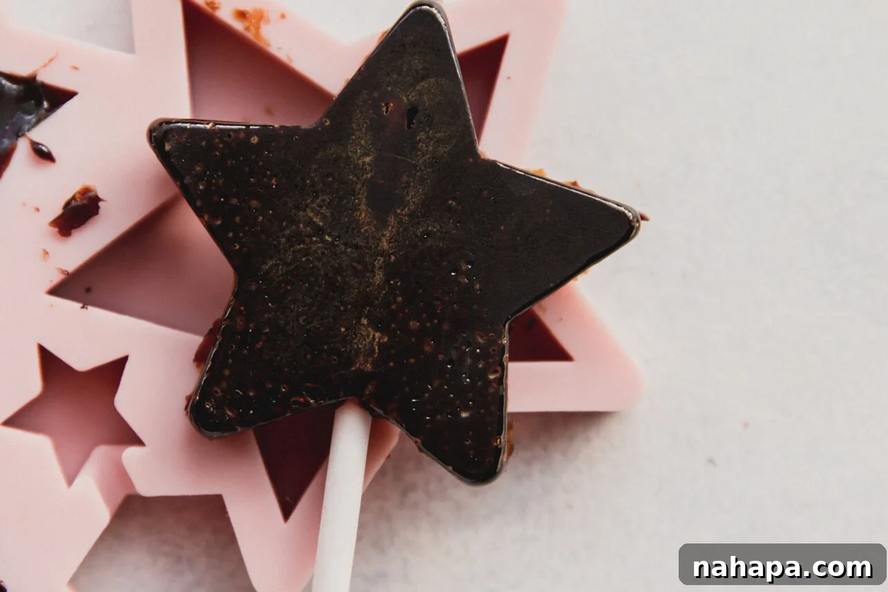 Three star-shaped elderberry lollipops, vibrant and perfectly set, ready for enjoyment.