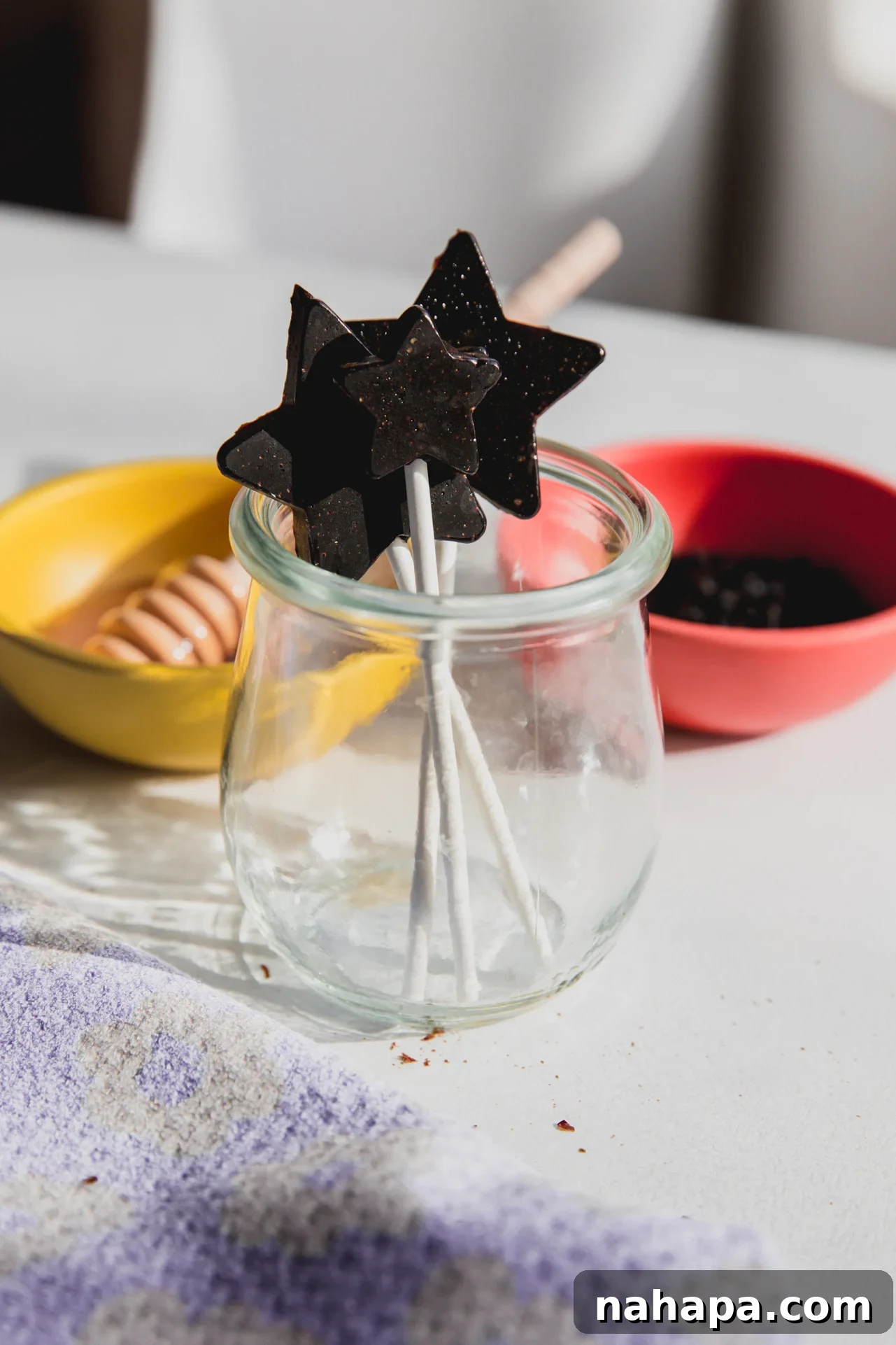 Three star shaped elderberry lollipops in a charming glass jar, ready for easy access and winter wellness support.