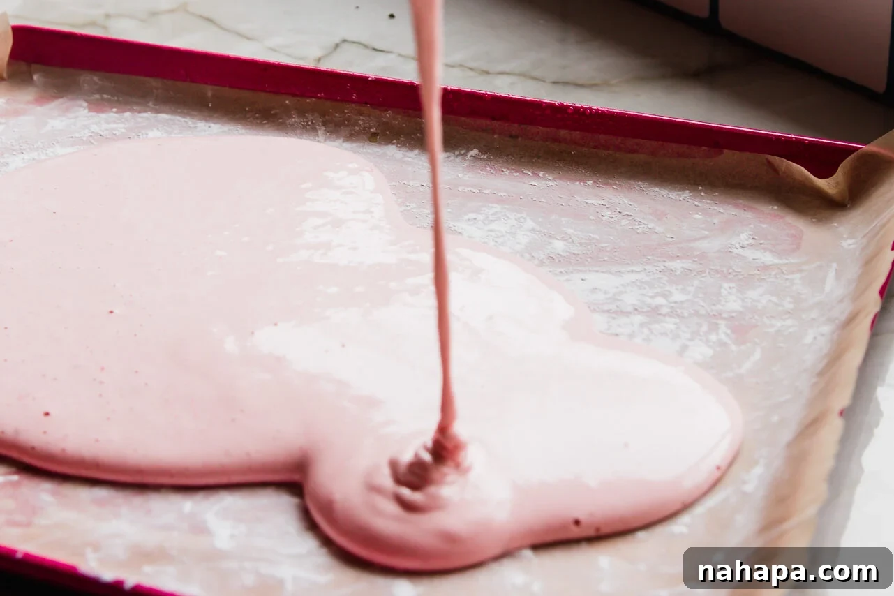 Sweet Pink Cloud Bites 5 prepared marshmallow mixture on a baking sheet lined with parchment paper and coated with arrowroot starch