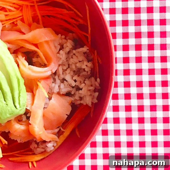 A bowl with rice, tomato, and carrots.