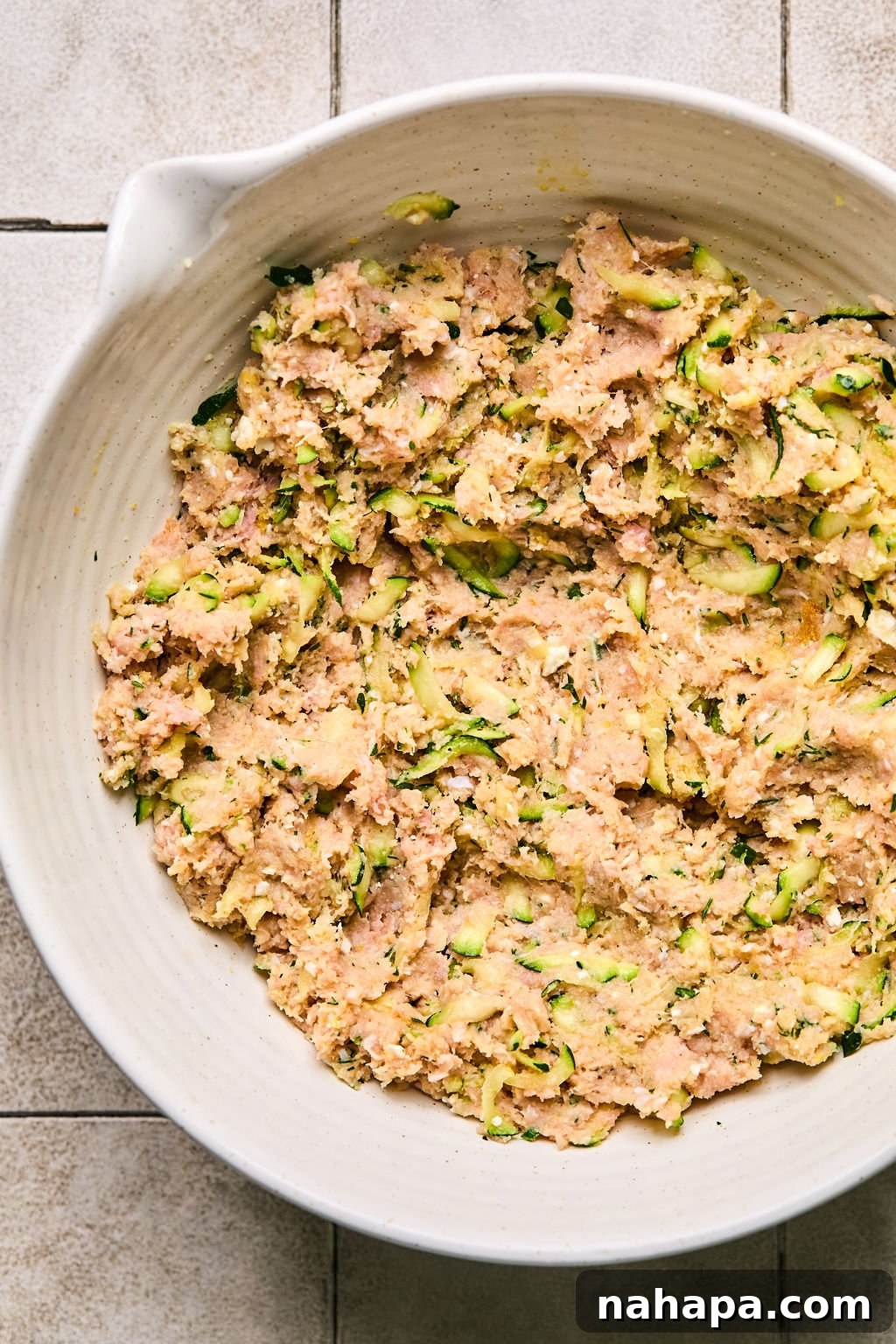 Zesty Gluten-Free Turkey Feta Bites 6 The ground turkey, zucchini, flours, feta, and herbs mixture, fully combined in a bowl and ready to be shaped into meatballs.