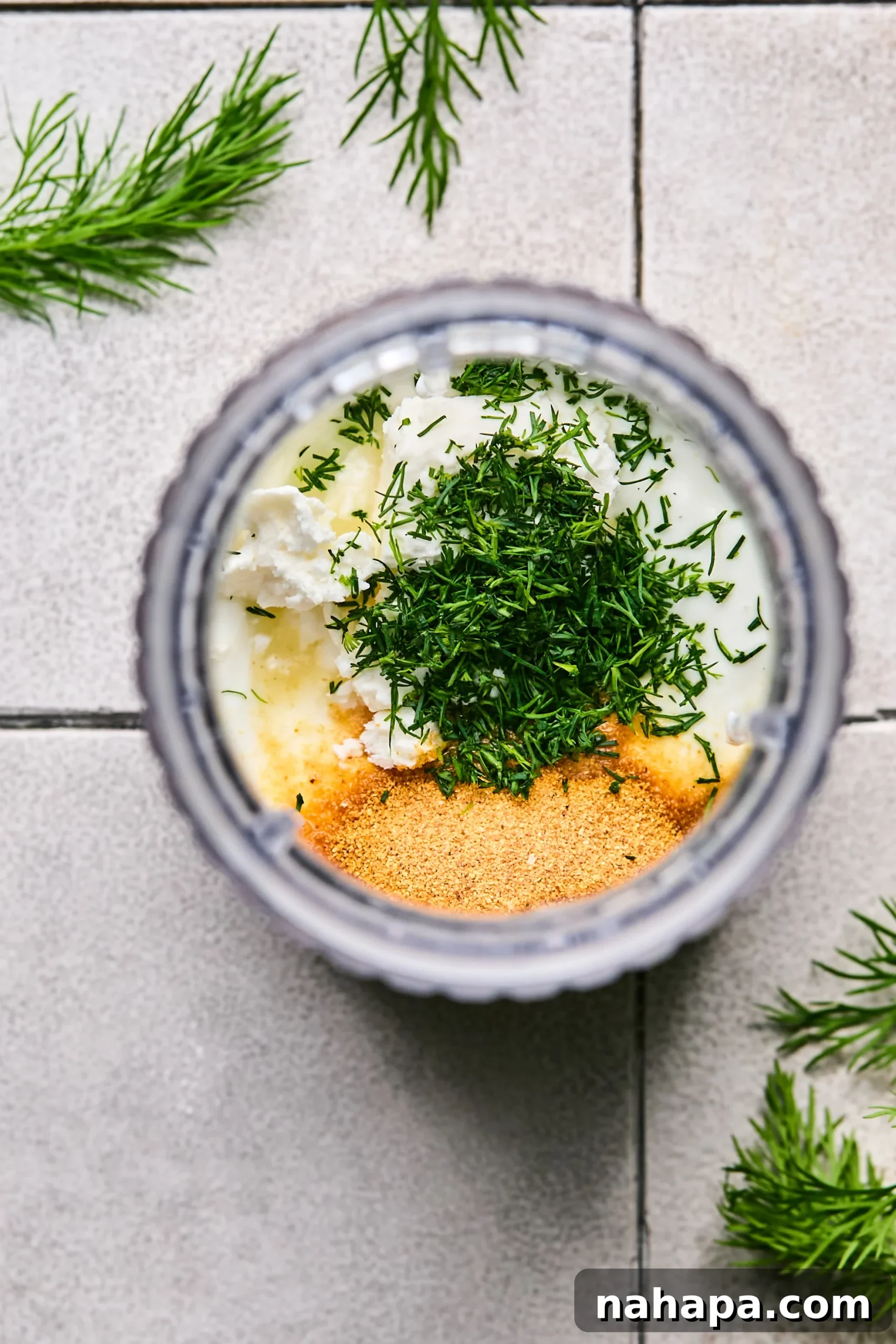 Zesty Gluten-Free Turkey Feta Bites 8 All ingredients for the creamy yogurt sauce, including coconut yogurt, feta, lemon juice, garlic powder, and fresh dill, placed in a tall mixing cup.