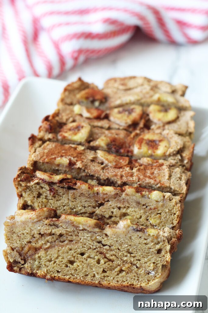 A rustic platter showcasing a whole loaf of AIP banana bread, ready to be sliced and enjoyed.