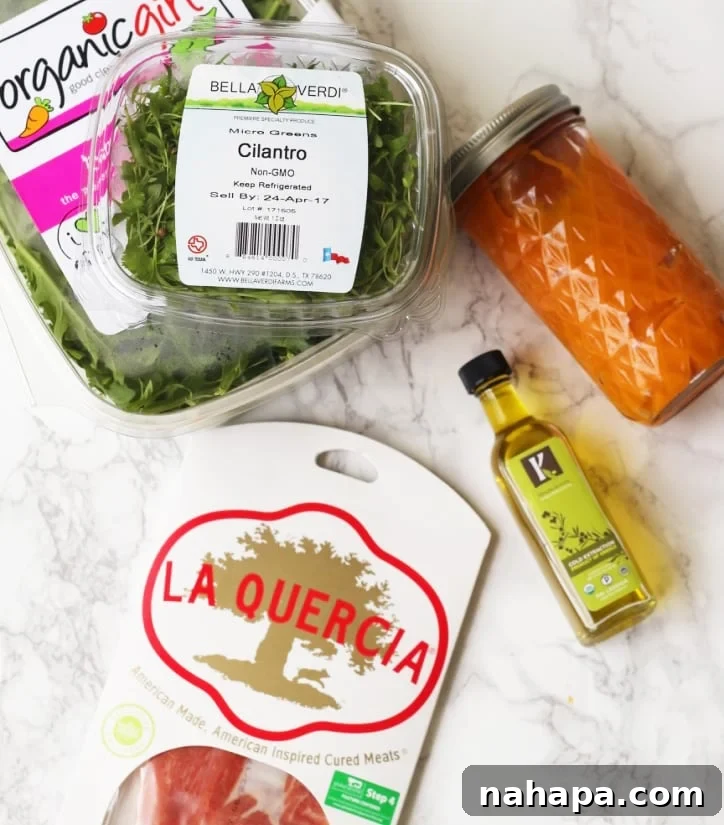 Your Paleo & AIP Travel Food Guide & Checklist 3 A container of green and cilantro, olive oil, cured meats, and dressing before being combined.