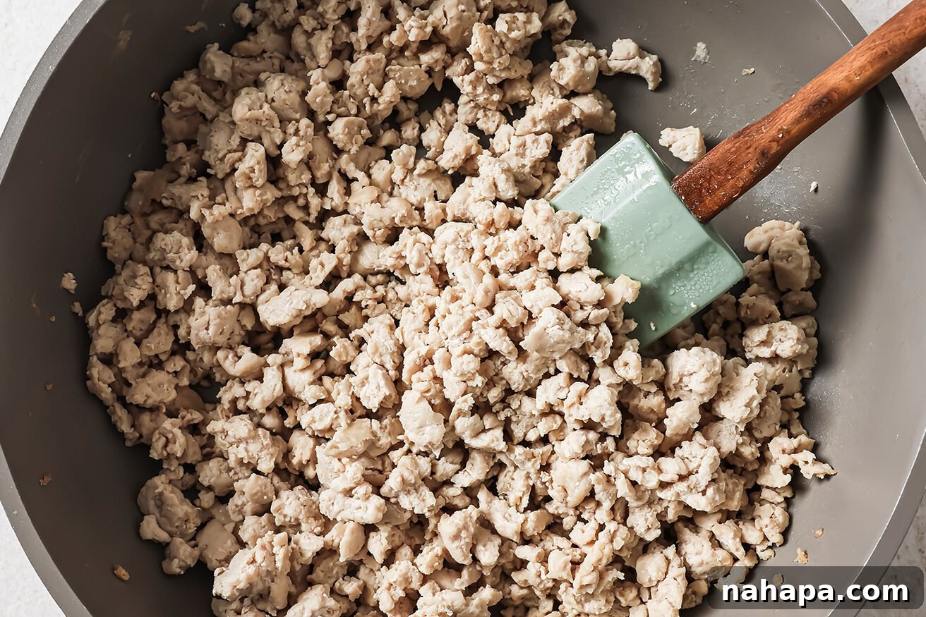 Close-up of cooked ground chicken in a pan, perfectly browned and crumbled, ready for the sauce.