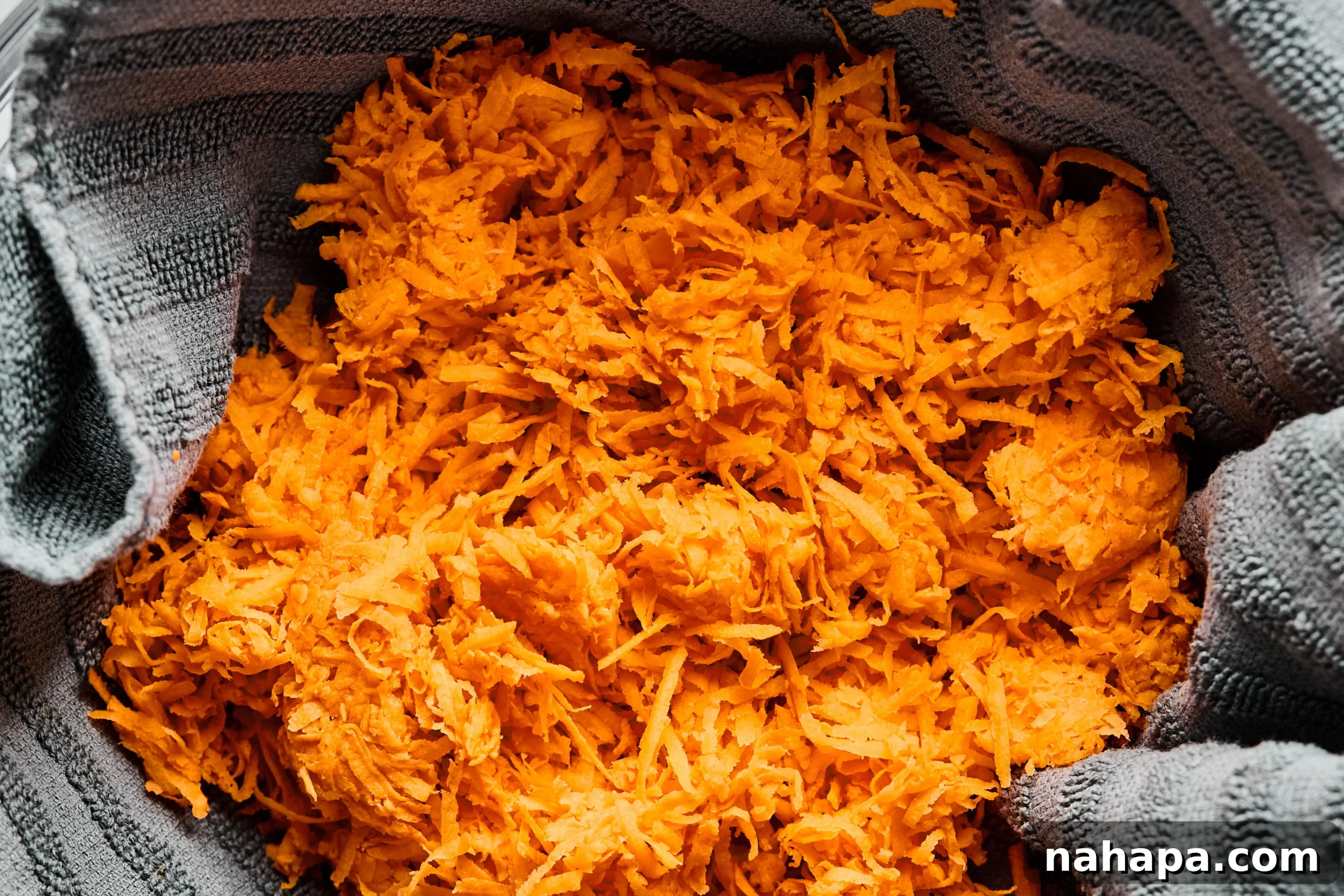 Shredded sweet potato in a towel to squeeze out excess water.