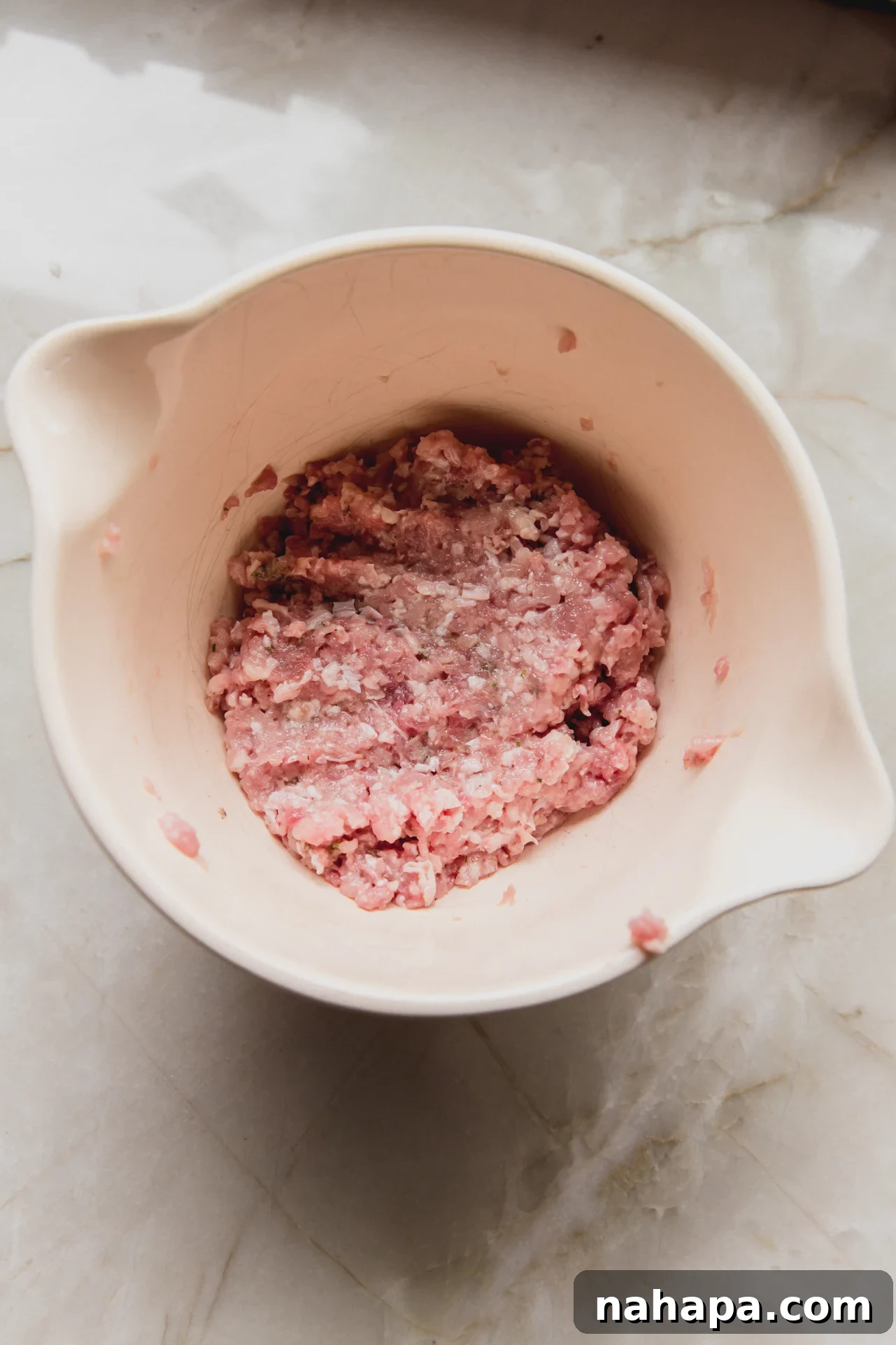 Seasoned ground chicken mixture in a bowl, ready to be spread onto tortillas.