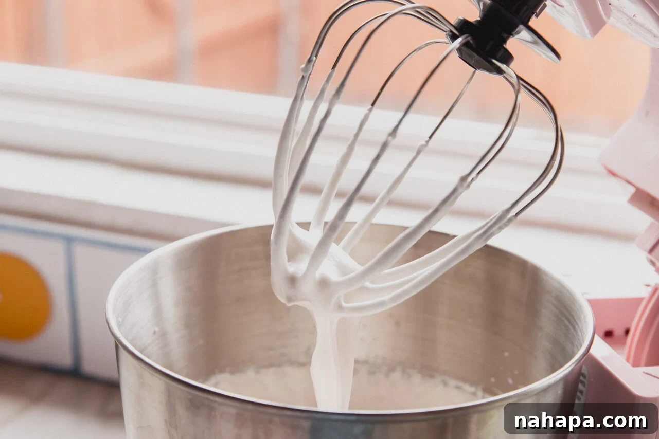 A stand mixer bowl after successfully whipping the protein marshmallow layer to achieve stiff peaks, indicating perfect consistency.