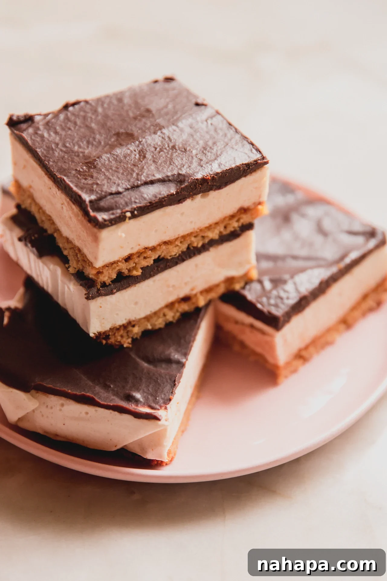 Protein s'mores bars sliced and stacked on a pink plate.