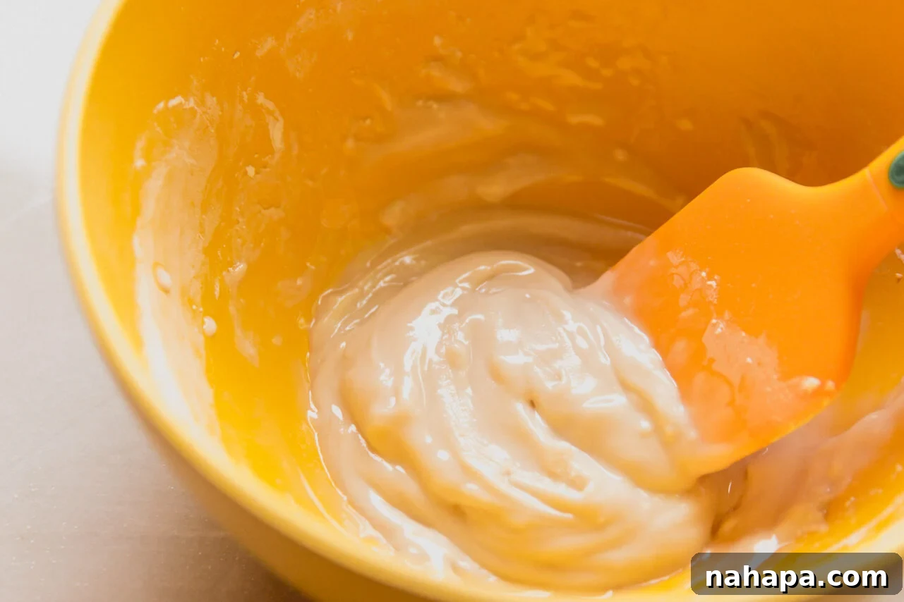 A bowl containing a thick, smooth white icing made from powdered sugar, water, and vanilla extract.