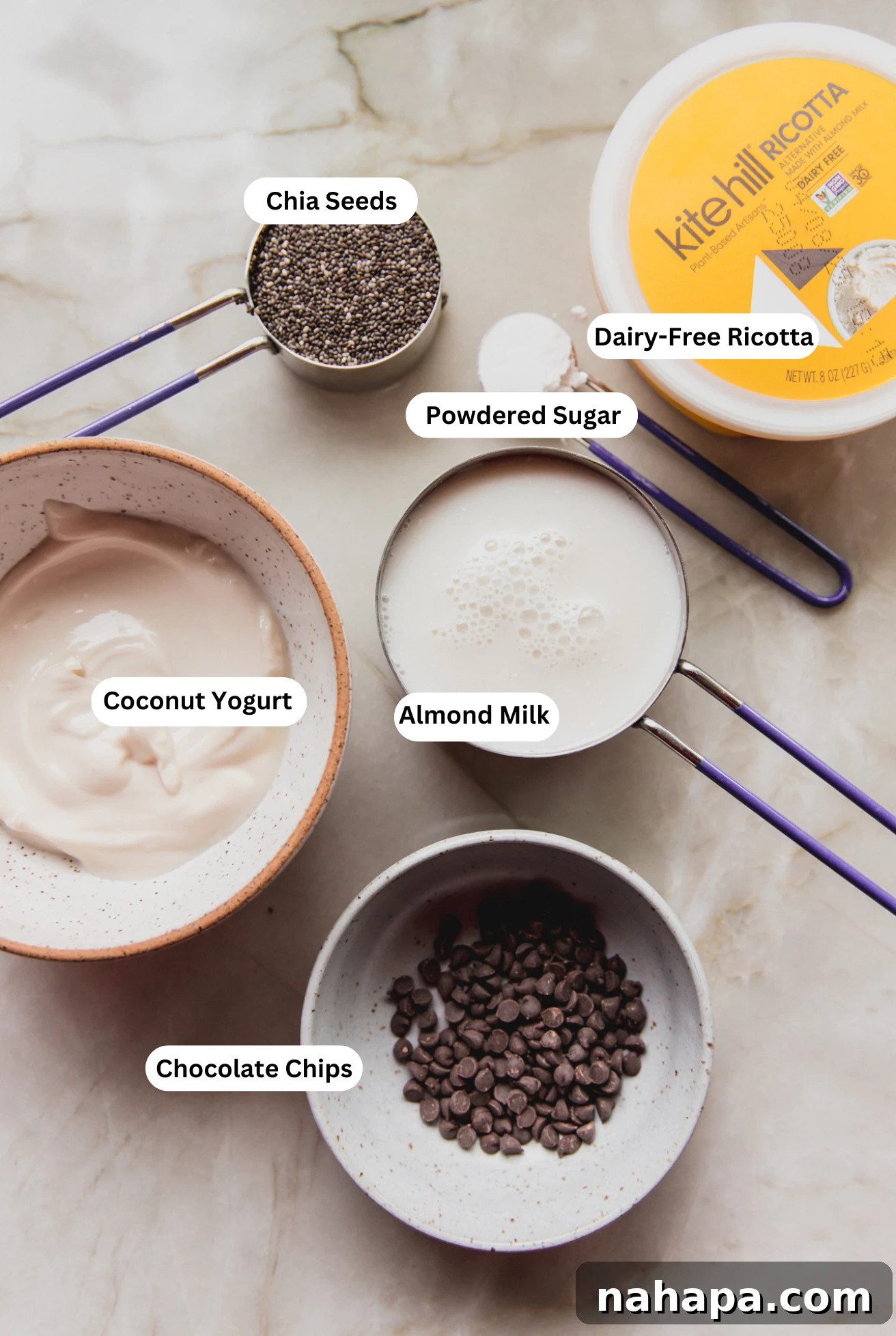 All of the ingredients to make cannoli chia seed pudding ready on a counter, neatly arranged.