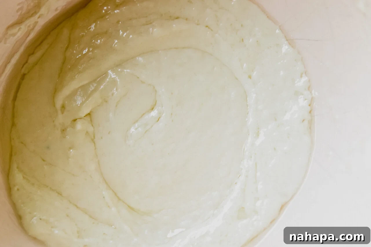 Melted shredded cheese and cream cheese in a bowl, showing a smooth, bubbly consistency.