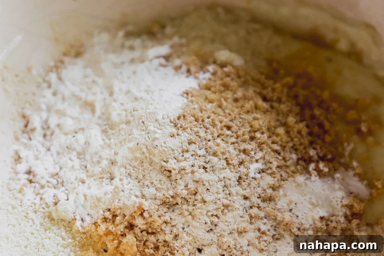 Gluten-free dough ingredients including almond flour, pork panko, and arrowroot starch added to melted cheese.