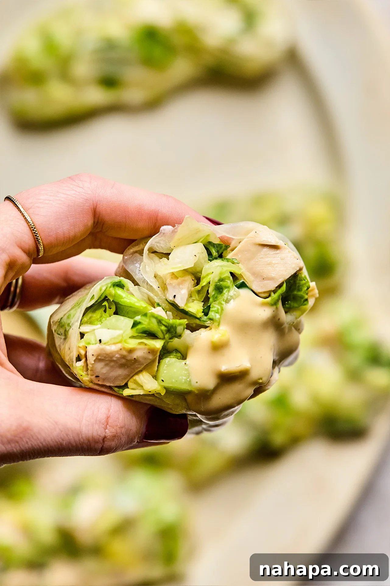 Chicken Caesar Summer Rolls 2 Caesar rice paper roll cut in half with some dressing.