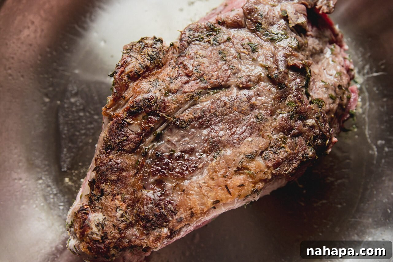 The chuck roast after being perfectly seared to a golden brown, creating a flavorful crust.