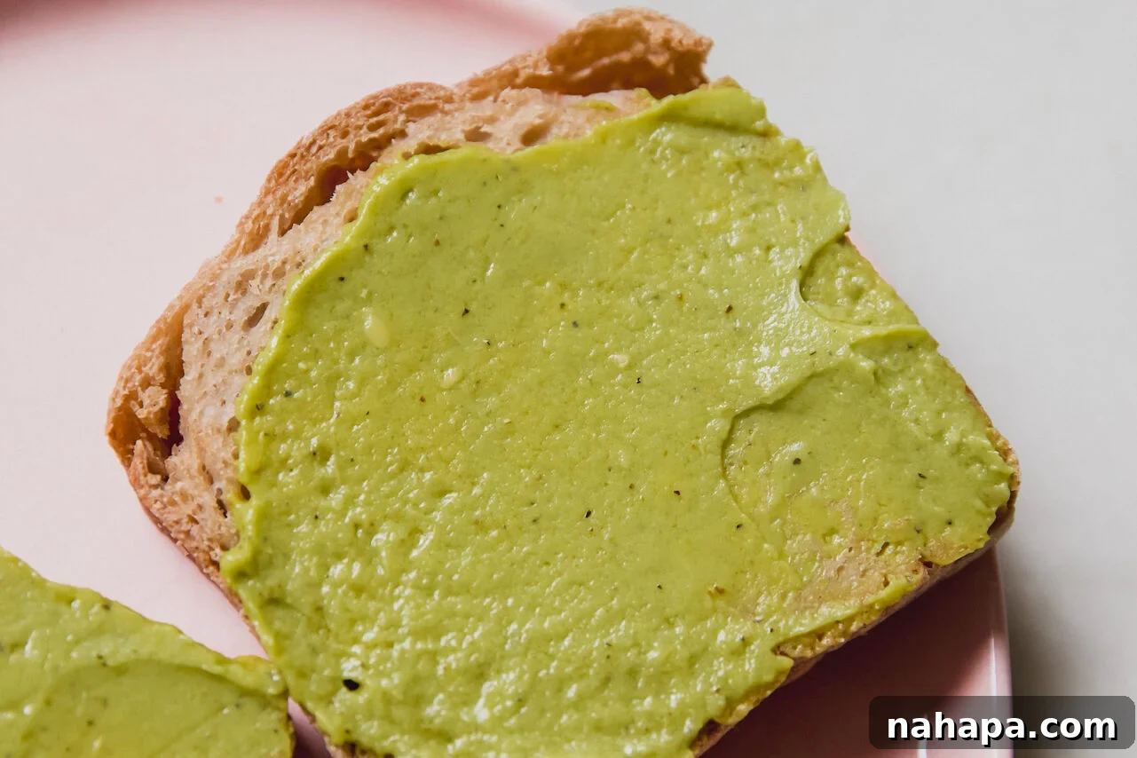 A piece of toast with avocado spread on top.