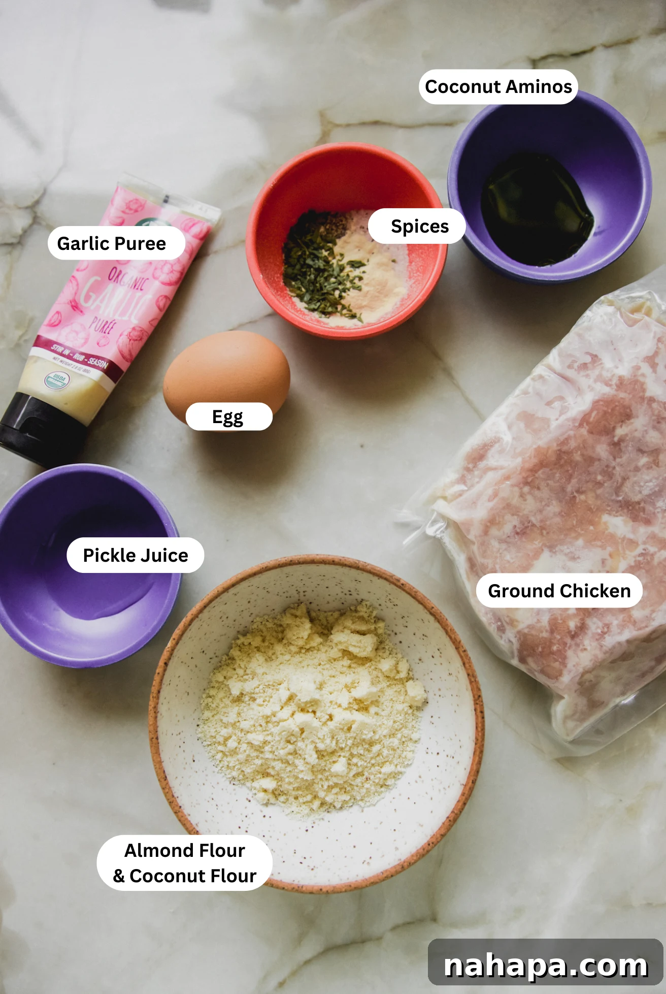 A flat lay photograph showcasing all the fresh ingredients needed for making air fryer chicken burgers.