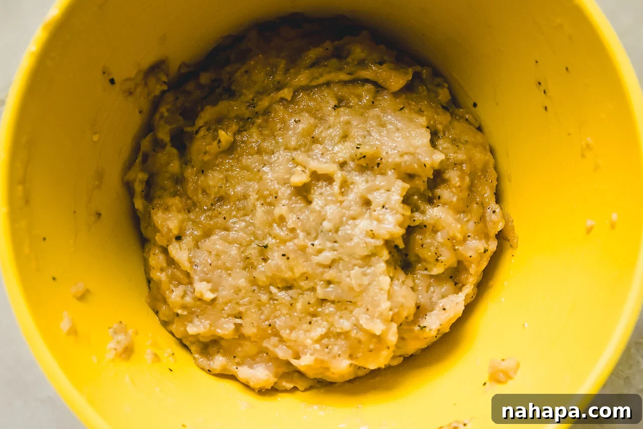 The ground chicken mixture in a mixing bowl, perfectly combined before patty formation.