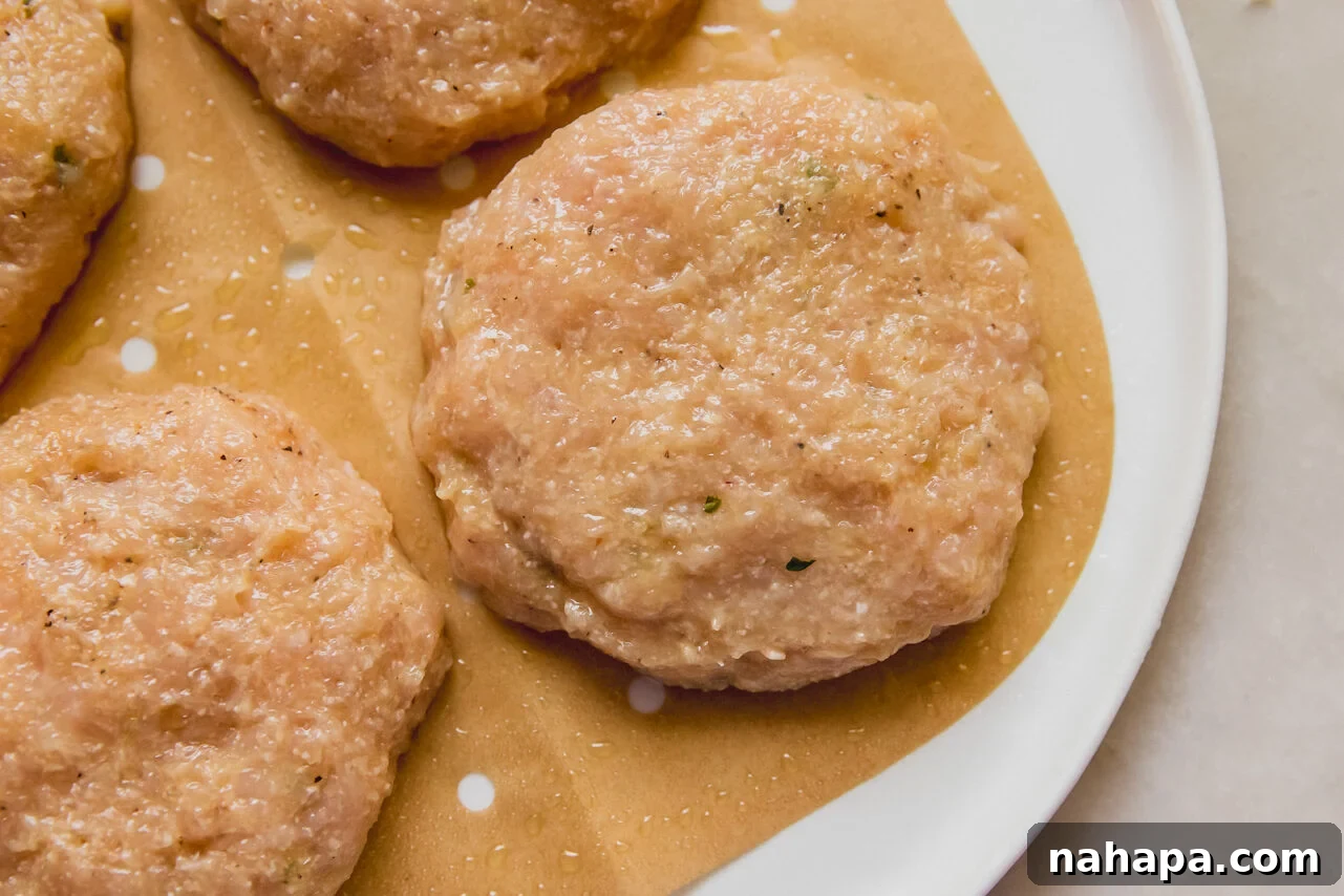 Neatly formed chicken patties resting on a plate, ready for chilling.