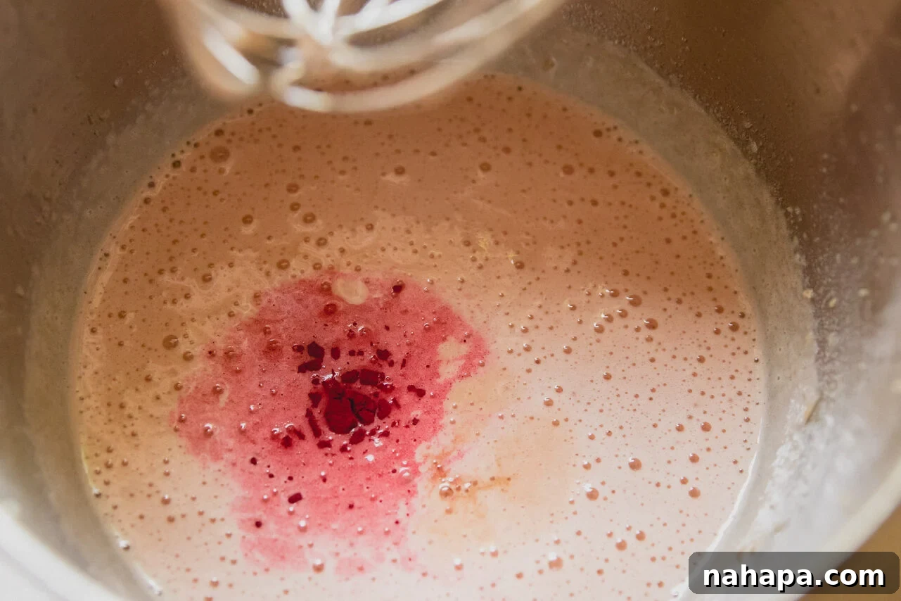 Watermelon Cloud Treats 6 The pink marshmallow mixture being vigorously mixed in a stand mixer, demonstrating its fluffy texture.