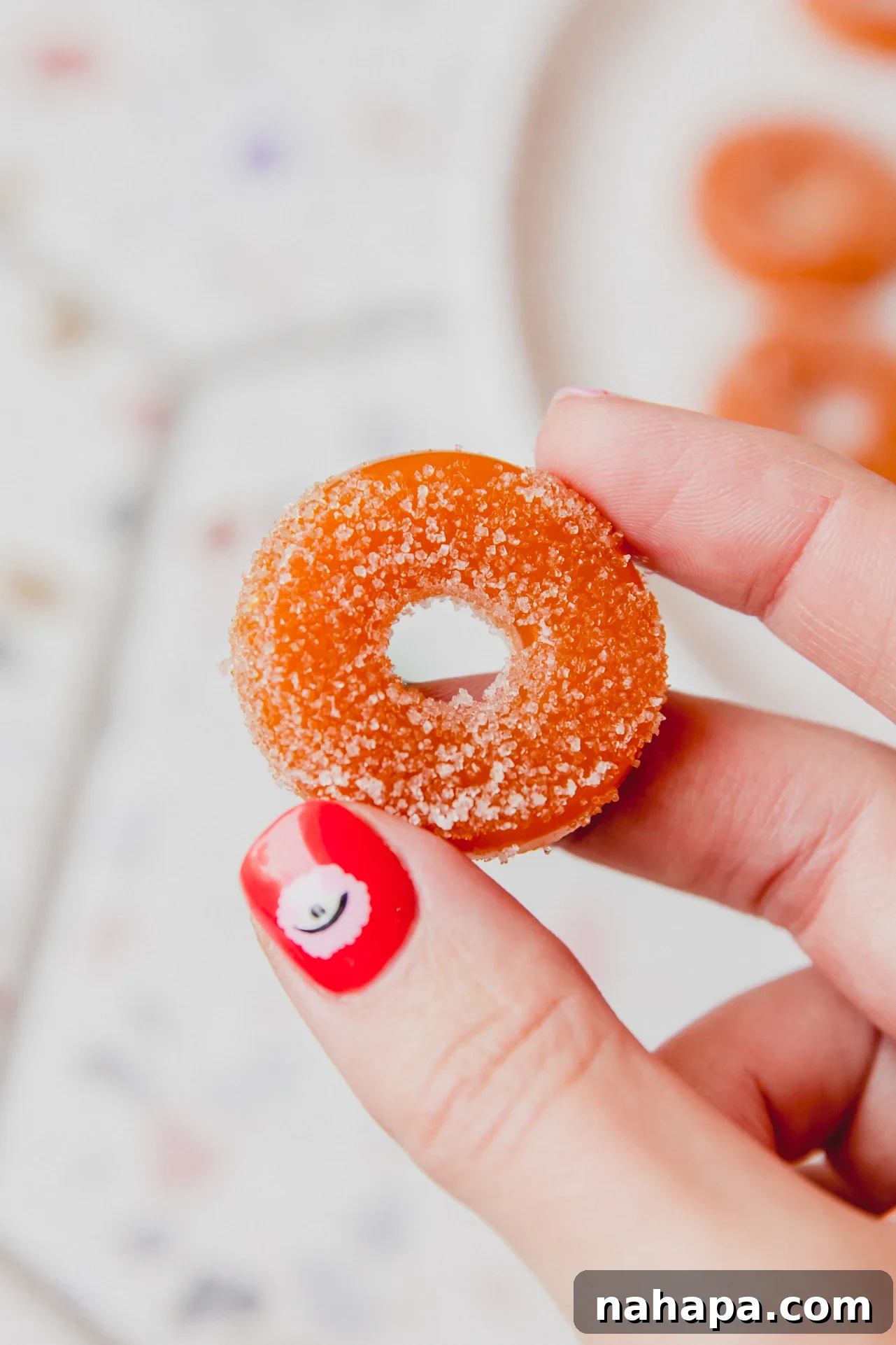 Peachy Protein Rings 2 Protein peach ring being held up, showcasing its vibrant color and chewy texture.