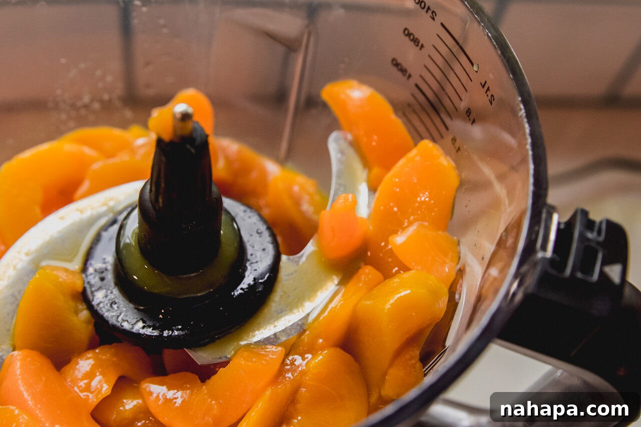 Peachy Protein Rings 4 Sliced peaches and orange juice being blended in a food processor to create a smooth puree.