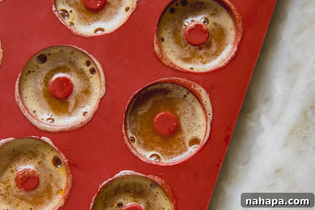 Peachy Protein Rings 7 Protein peach ring gummies setting in a red silicone mold, accurately filled.