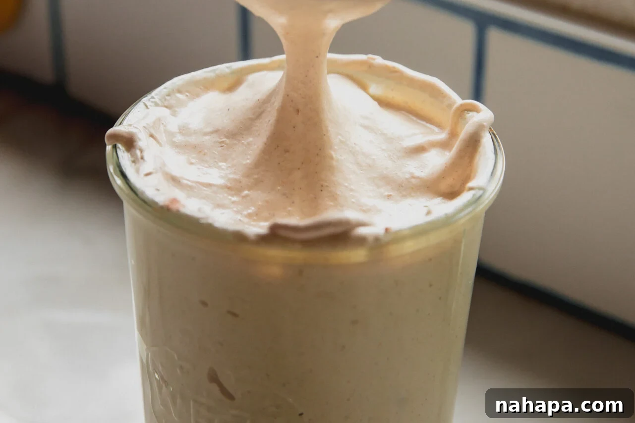 Pumpkin Spice Marshmallow Cloud 6 Pumpkin spice marshmallow fluff with a spoon scooping some of the fluff.