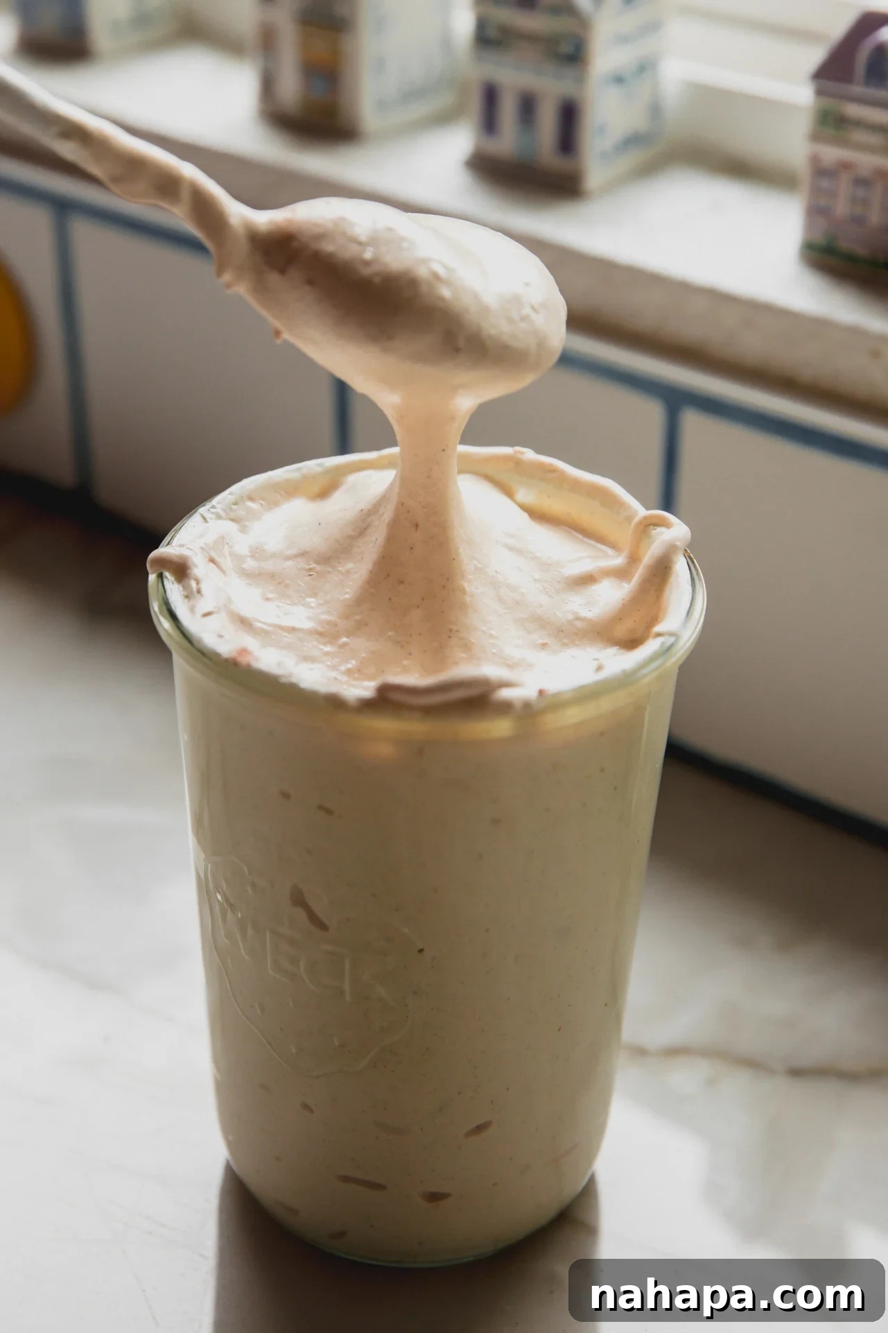 Pumpkin Spice Marshmallow Cloud 7 A spoon putting pumpkin pie marshmallow fluff into a glass jar.