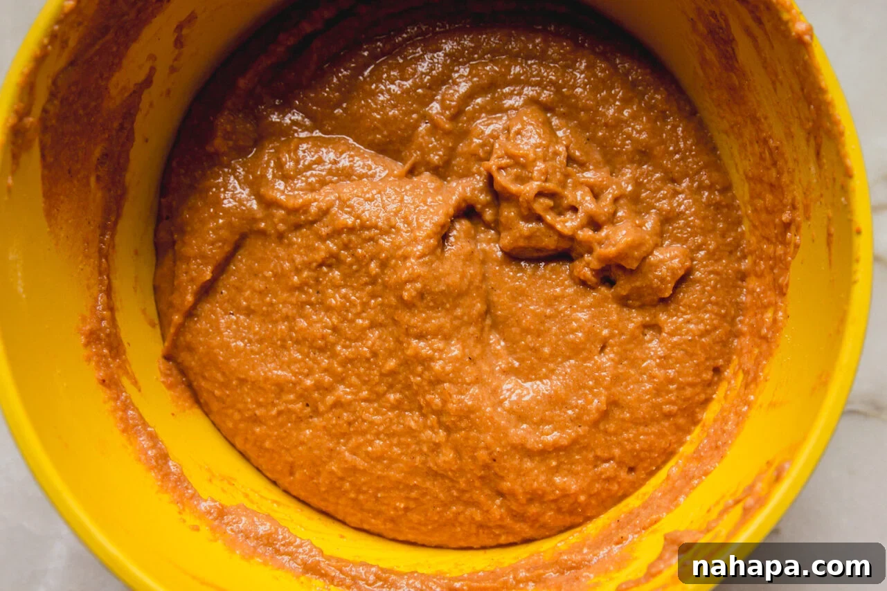 Spiced Almond Pumpkin Bread 6 Smooth almond flour pumpkin loaf batter in a yellow mixing bowl, ready for baking.