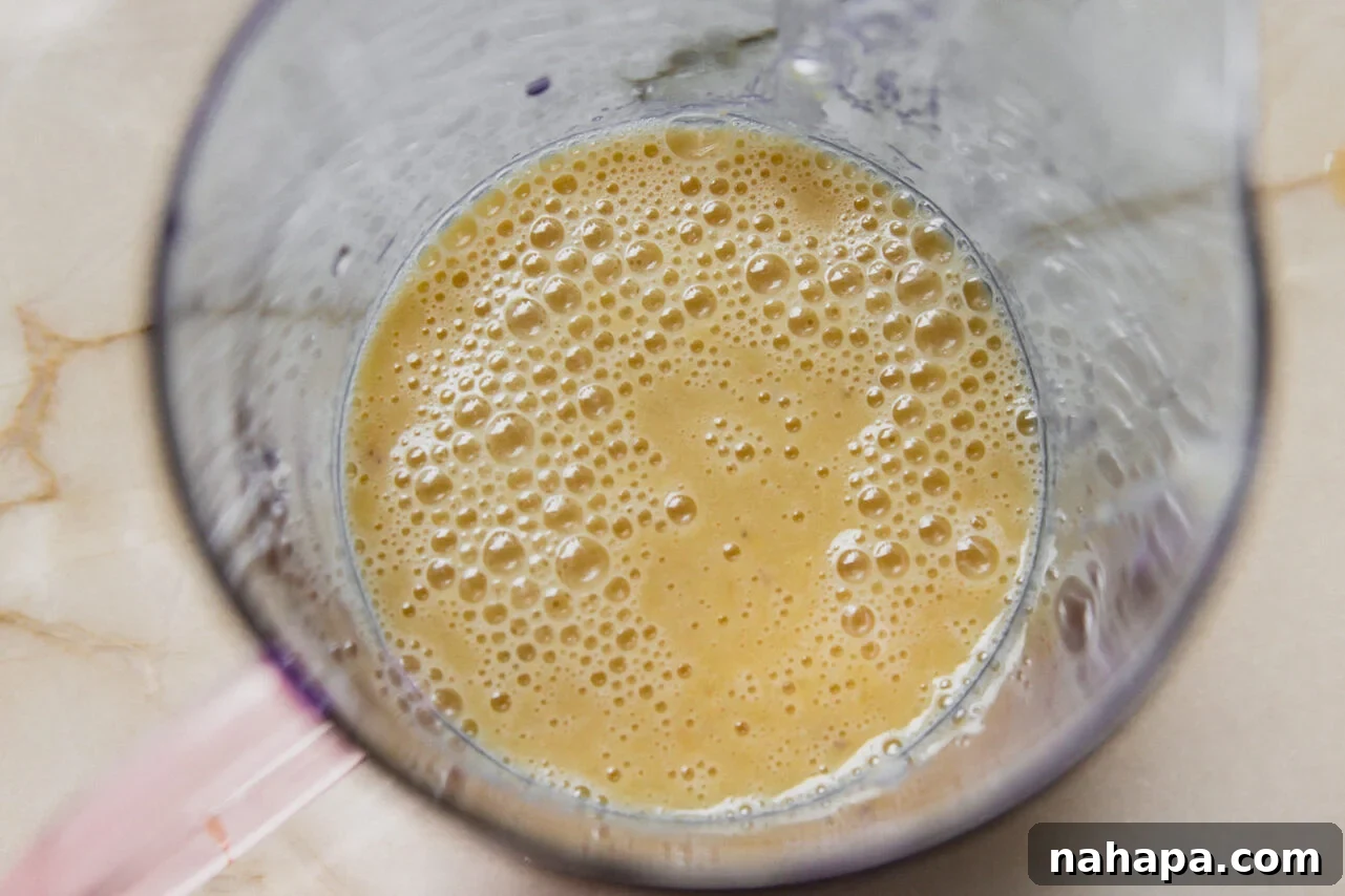 Blended wet ingredients for banana protein breakfast cake in a measuring cup.