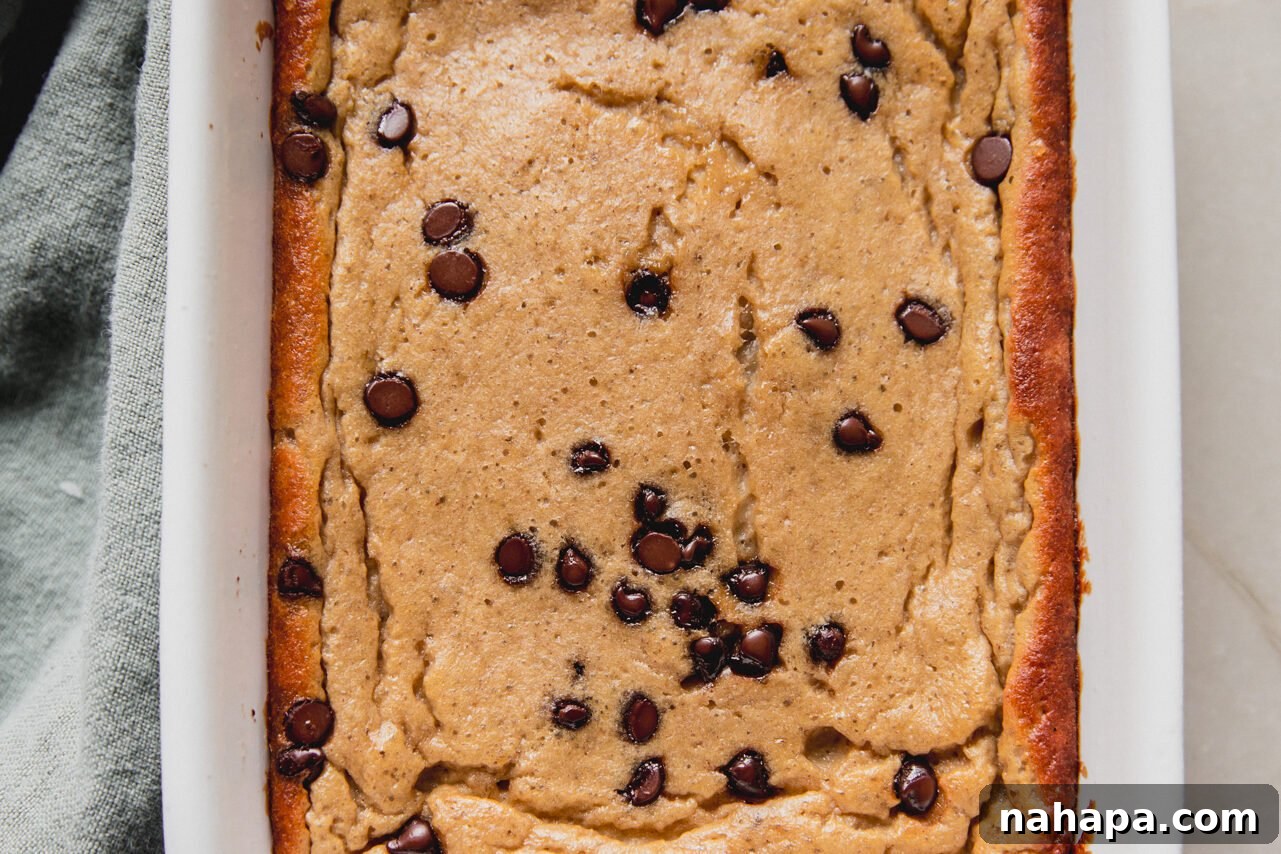 Baked banana protein breakfast cake, golden brown and ready to be sliced.