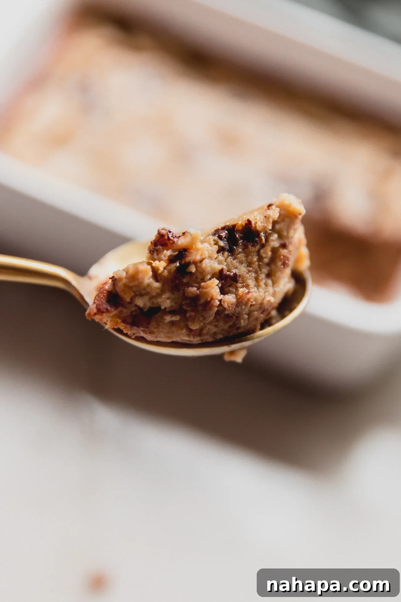 A large spoonful of warm banana protein breakfast cake, topped with flaky salt, ready to be eaten.