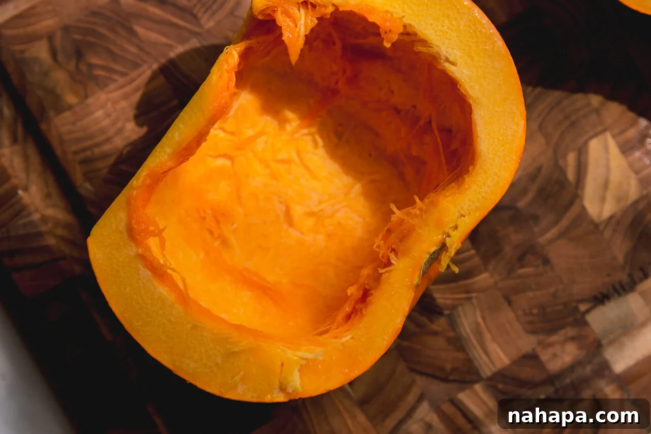 One half of a sugar pumpkin, seeds completely removed, with its bright orange flesh lightly drizzled with avocado oil and seasoned with salt and pepper.