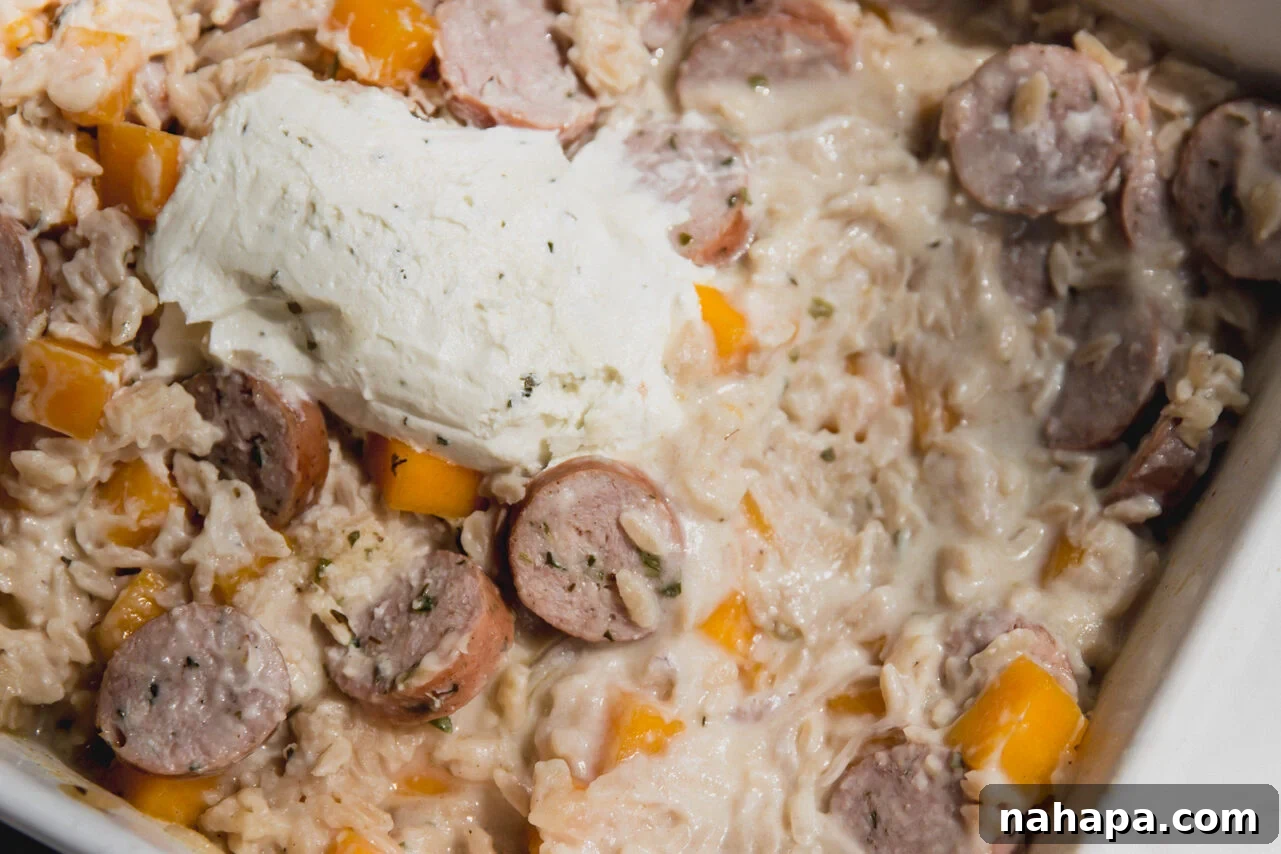 The chicken sausage and orzo bake after baking, before being mixed to create a creamy sauce.