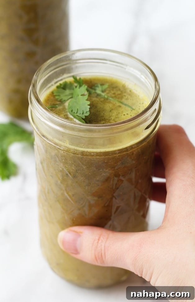 Mastering Your Microbiome The Essential Toolkit 2 A glass mug of bone broth green drink being held in a hand.