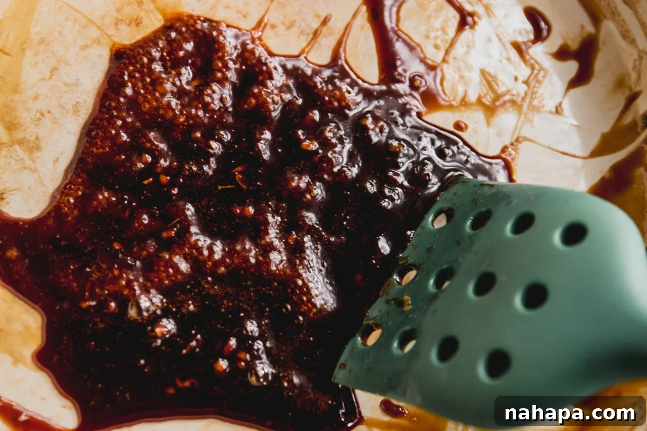 Sweet and sticky orange glaze reducing in a pan, bubbling gently to a perfect consistency.