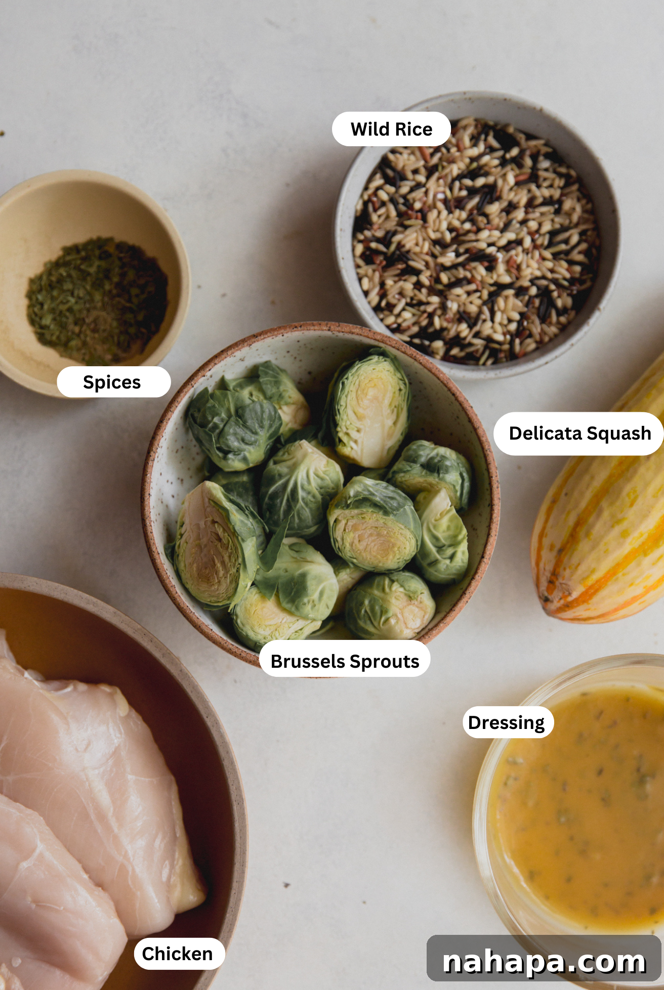 Golden Harvest Chicken & Squash Bowl 3 All the fresh ingredients laid out for preparing roasted squash and chicken harvest bowls, including delicata squash, chicken, kale, Brussels sprouts, and dressing components.