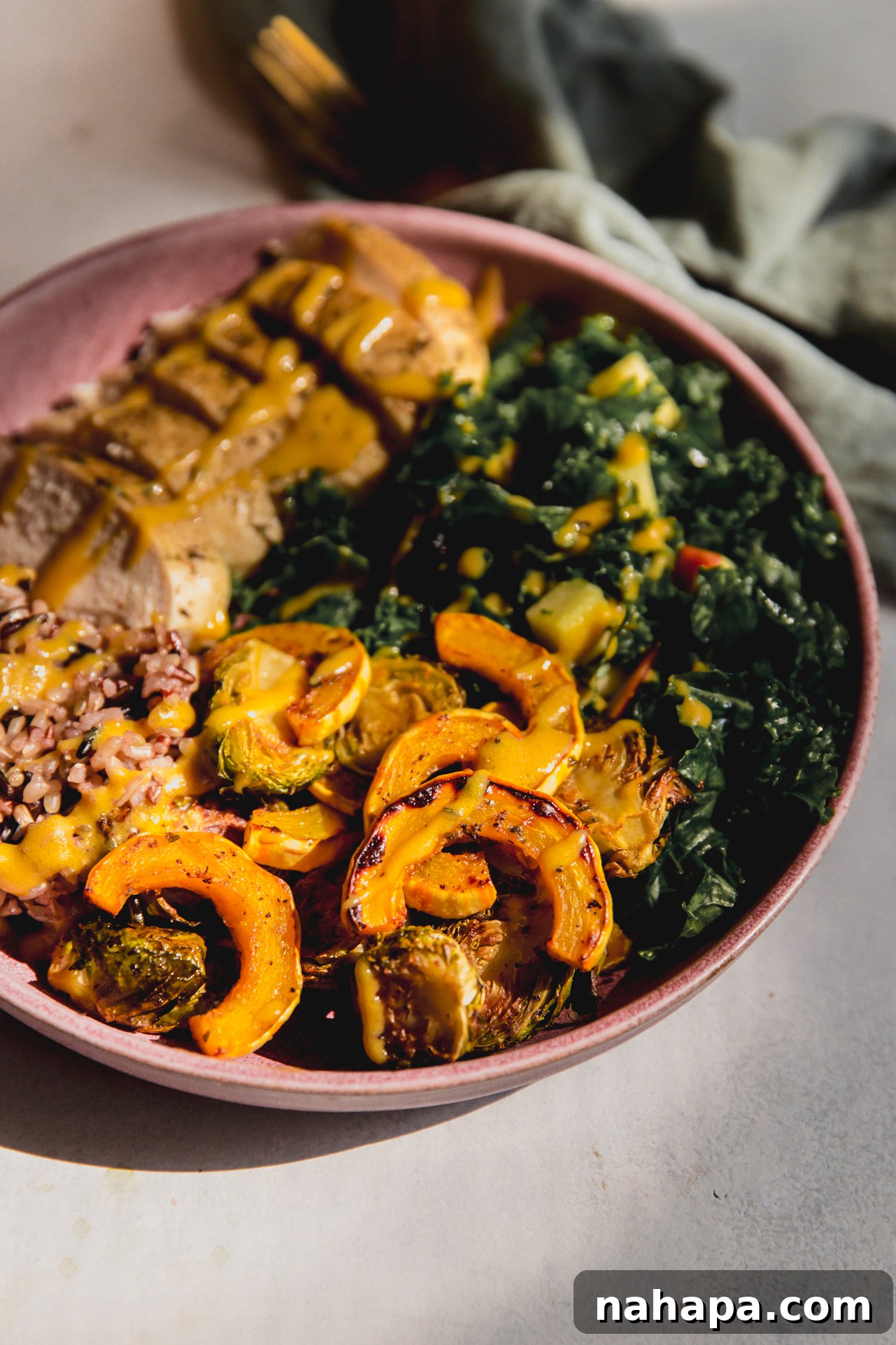 Golden Harvest Chicken & Squash Bowl 10 A vibrant and fully assembled harvest chicken bowl, richly topped with maple dijon dressing, showcasing all the delicious roasted and fresh components.